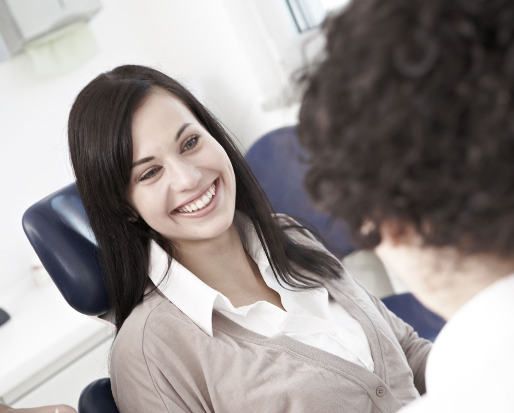 Wurzelkanalbehandlung Patientin lächelt behandelte Zahnärztin an